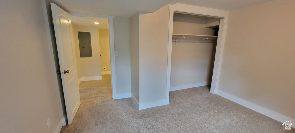 Unfurnished bedroom featuring carpet, electric panel, a closet, baseboards, and recessed lighting