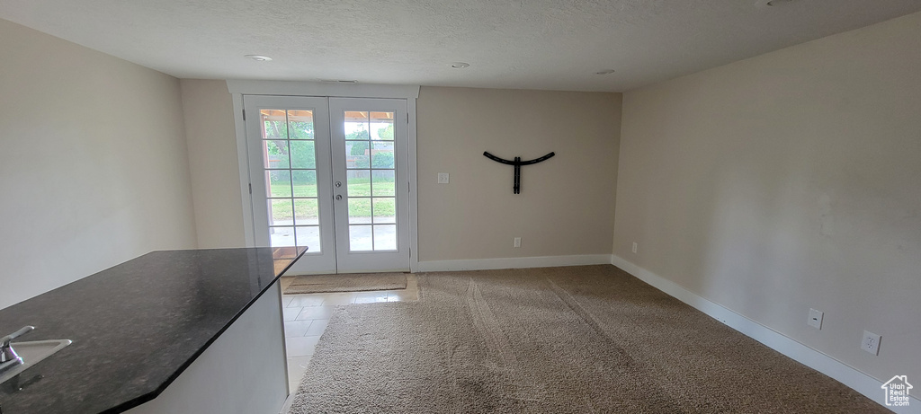 Entryway featuring french doors, a textured ceiling, baseboards, and recessed lighting