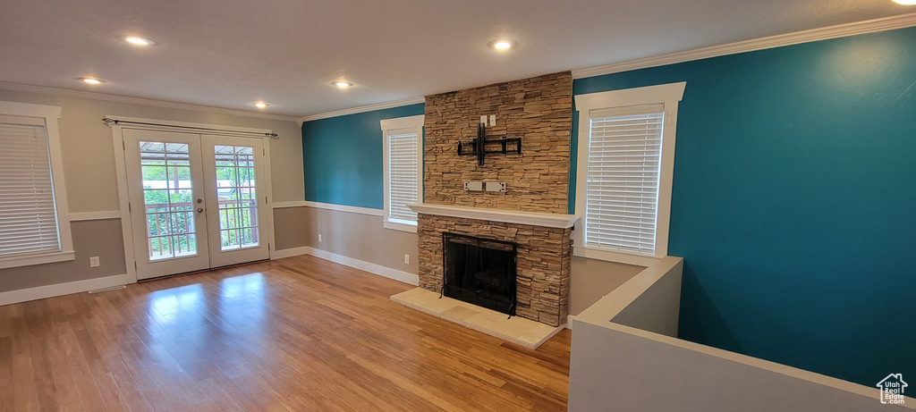 Unfurnished living room featuring ornamental molding, french doors, wood finished floors, recessed lighting, and baseboards