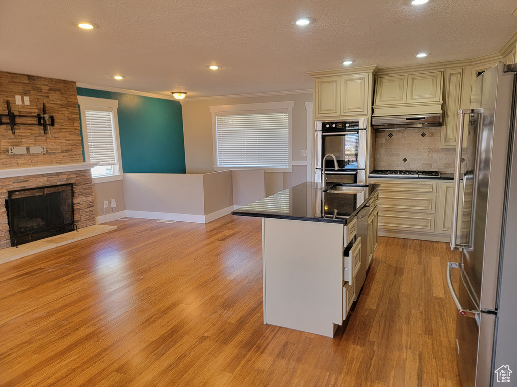 Kitchen featuring appliances with stainless steel finishes, a sink, dark countertops, light wood-style floors, and baseboards