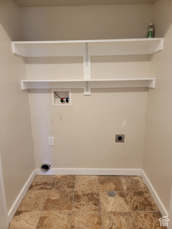 Laundry room featuring washer hookup, hookup for an electric dryer, baseboards, and stone finish floors