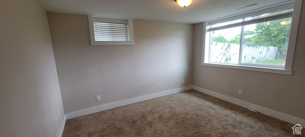 Unfurnished room featuring carpet and baseboards
