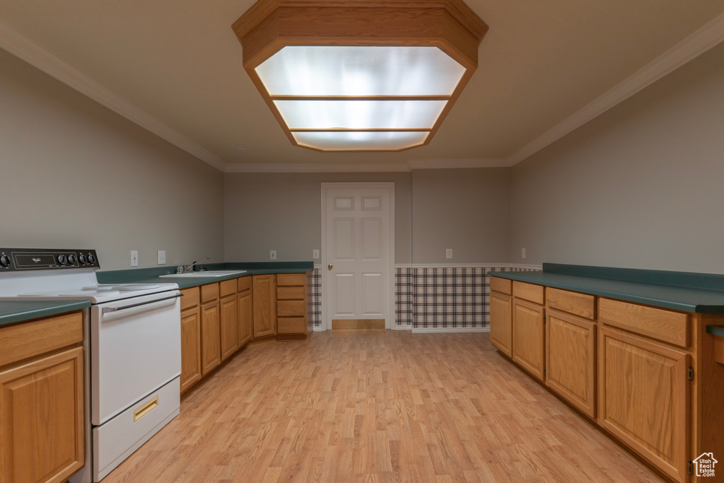 Kitchen featuring white range with electric cooktop, light wood-type flooring, crown molding, dark countertops, and a sink