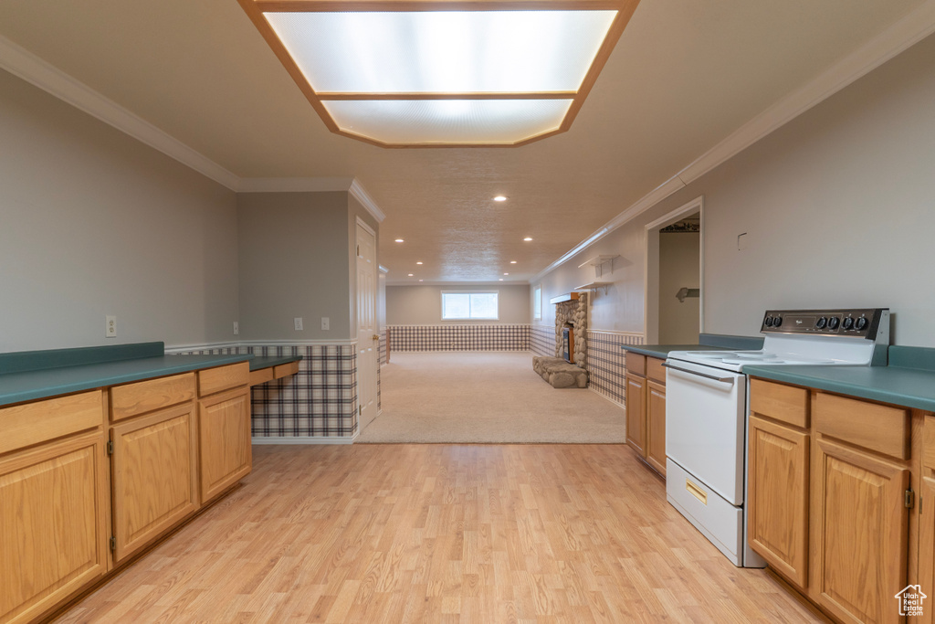 Kitchen featuring electric range, recessed lighting, crown molding, open floor plan, and light wood finished floors