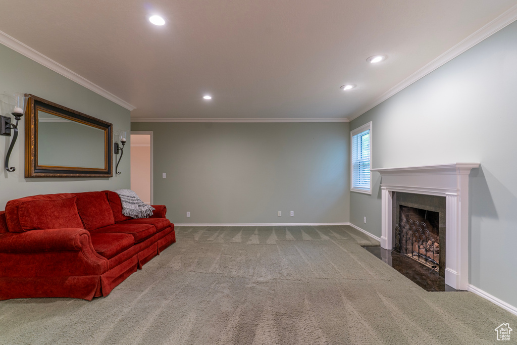 Carpeted living room with a fireplace with flush hearth, recessed lighting, baseboards, and ornamental molding