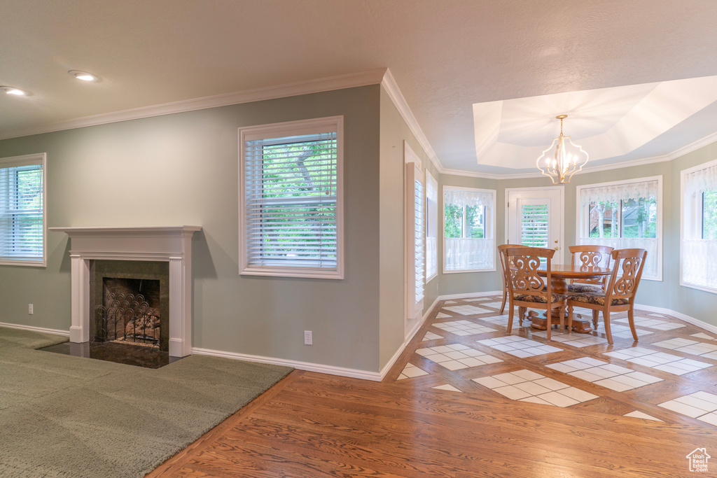 Dining area featuring healthy amount of natural light, baseboards, a fireplace with flush hearth, a chandelier, and recessed lighting