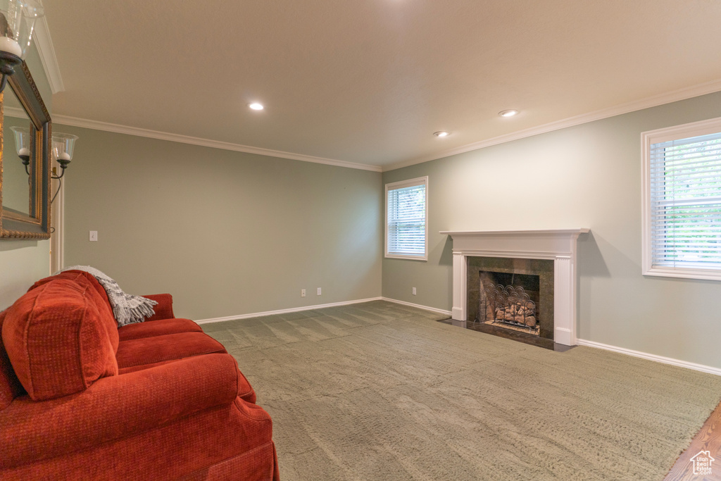 Living area featuring a tile fireplace, baseboards, crown molding, and recessed lighting