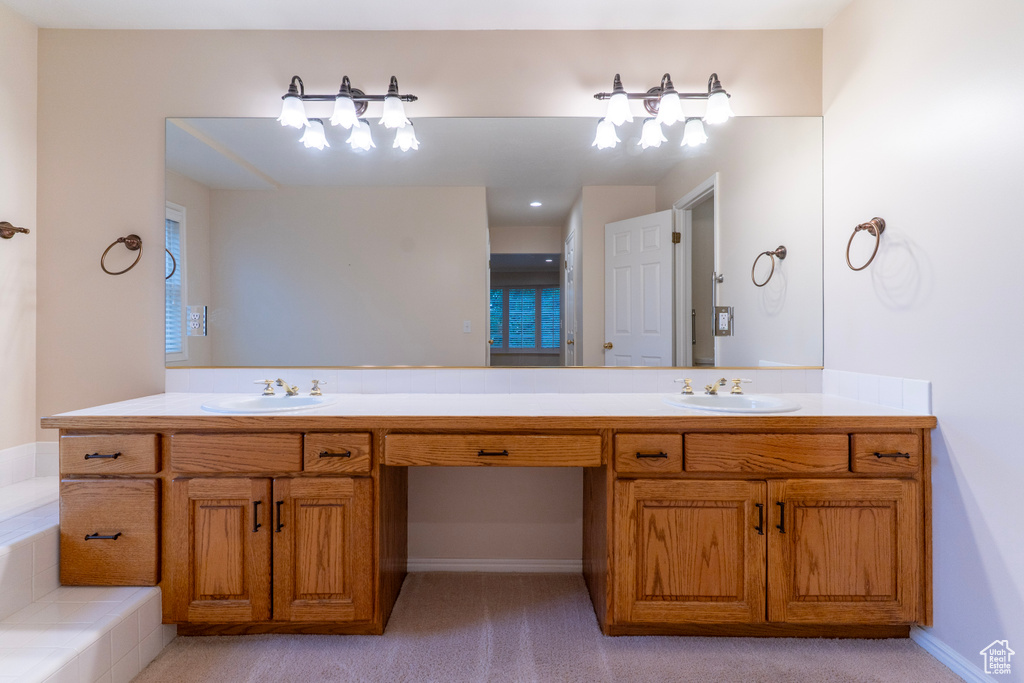 Bathroom featuring double vanity and a tub to relax in