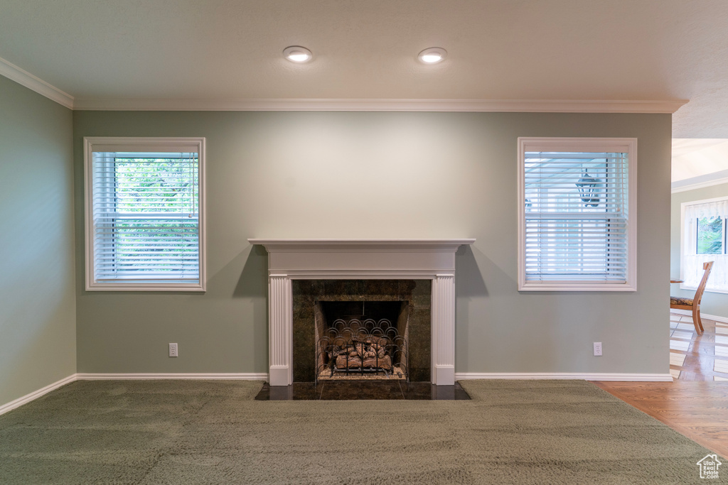 Unfurnished living room with ornamental molding, a premium fireplace, baseboards, and recessed lighting