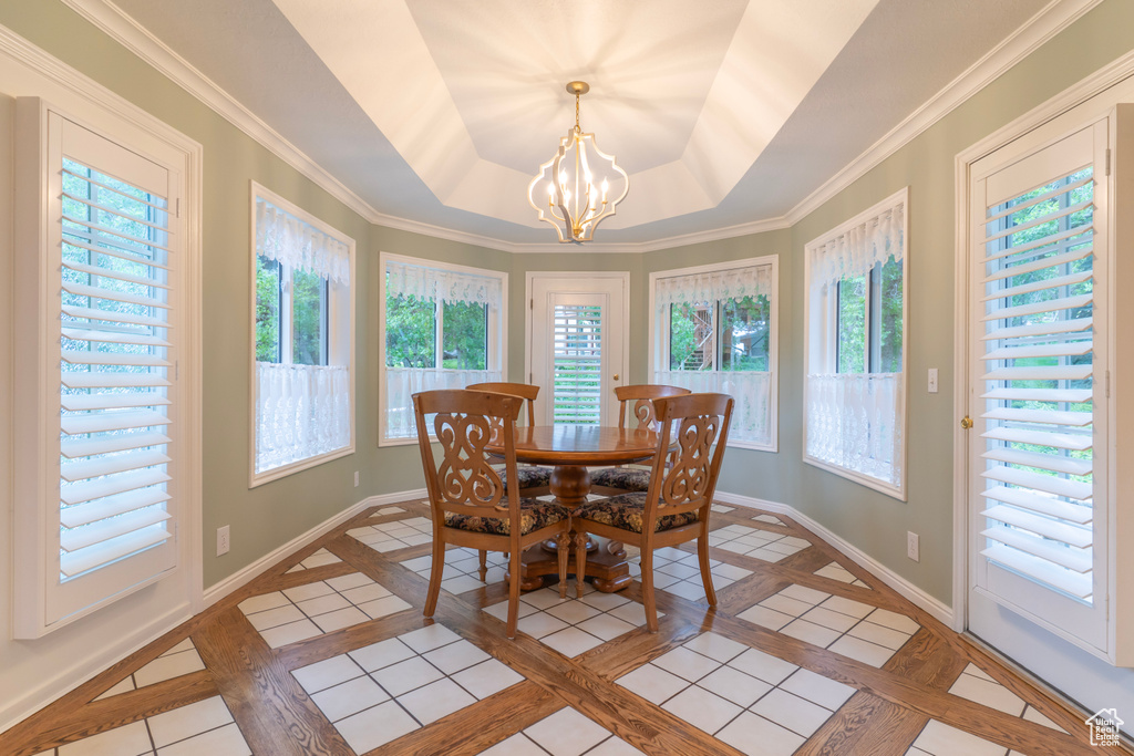 Dining area featuring a chandelier, inlaid floor details, and baseboards