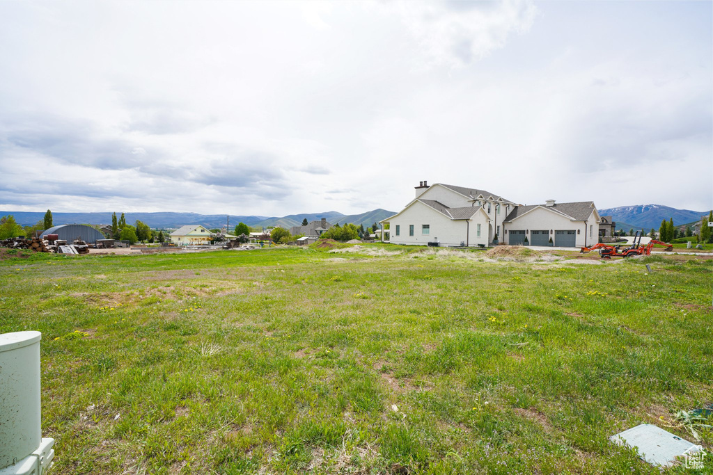 View of yard featuring an attached garage and a mountain view