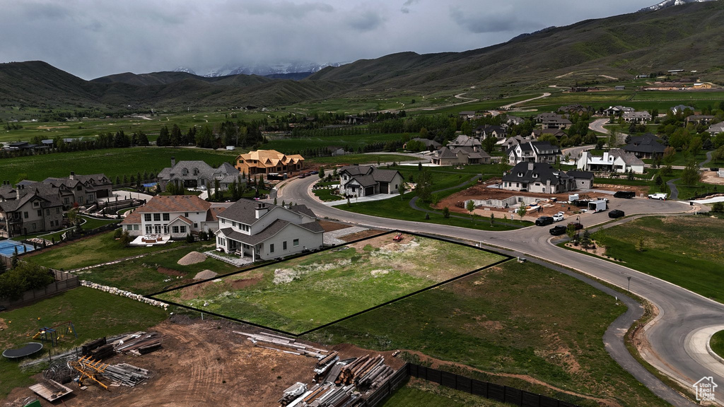 Aerial view of property and surrounding area with a mountainous background and nearby suburban area