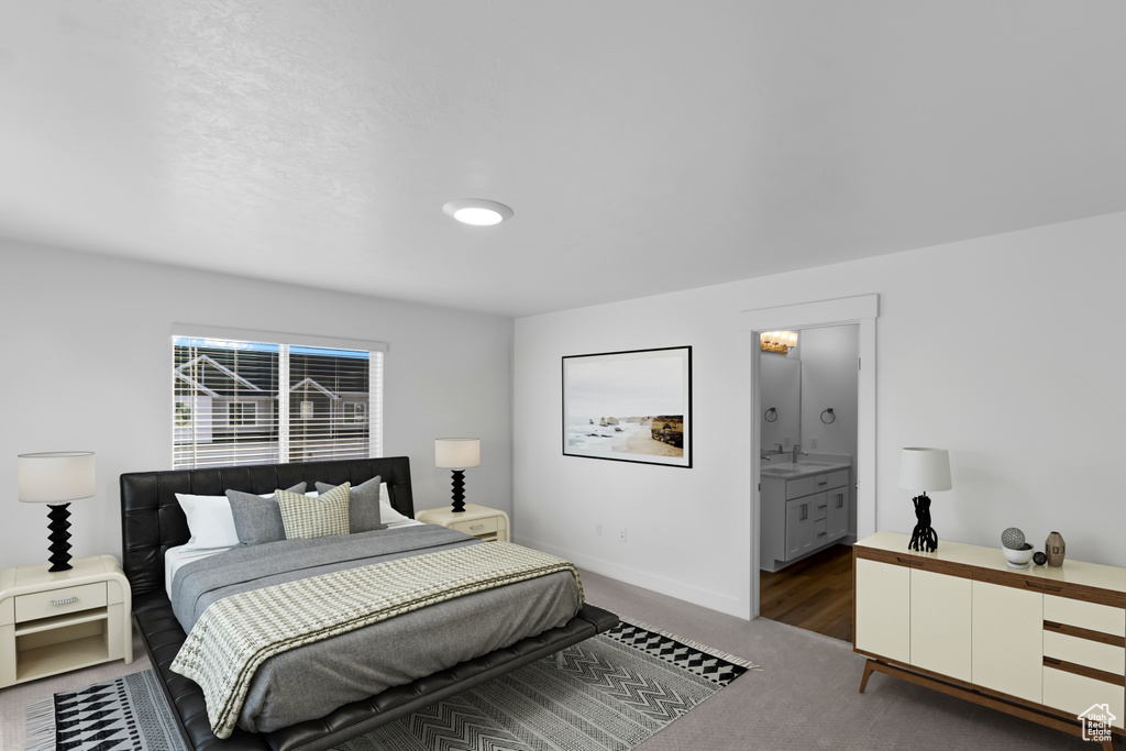 Bedroom featuring carpet floors, baseboards, a sink, and ensuite bath