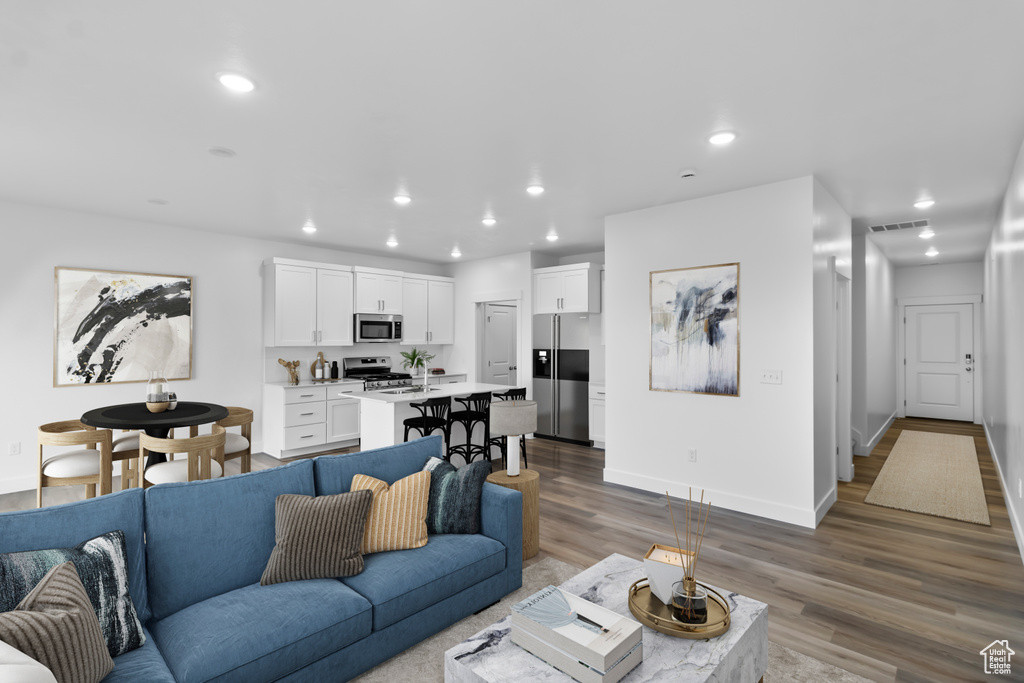 Living room featuring wood finished floors, recessed lighting, and baseboards