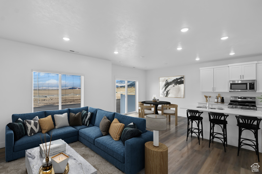 Living room featuring wood finished floors, recessed lighting, and baseboards