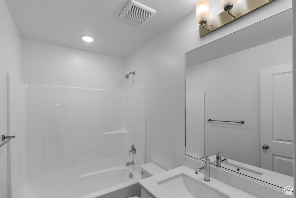 Bathroom featuring toilet, shower / bath combination, vanity, and recessed lighting