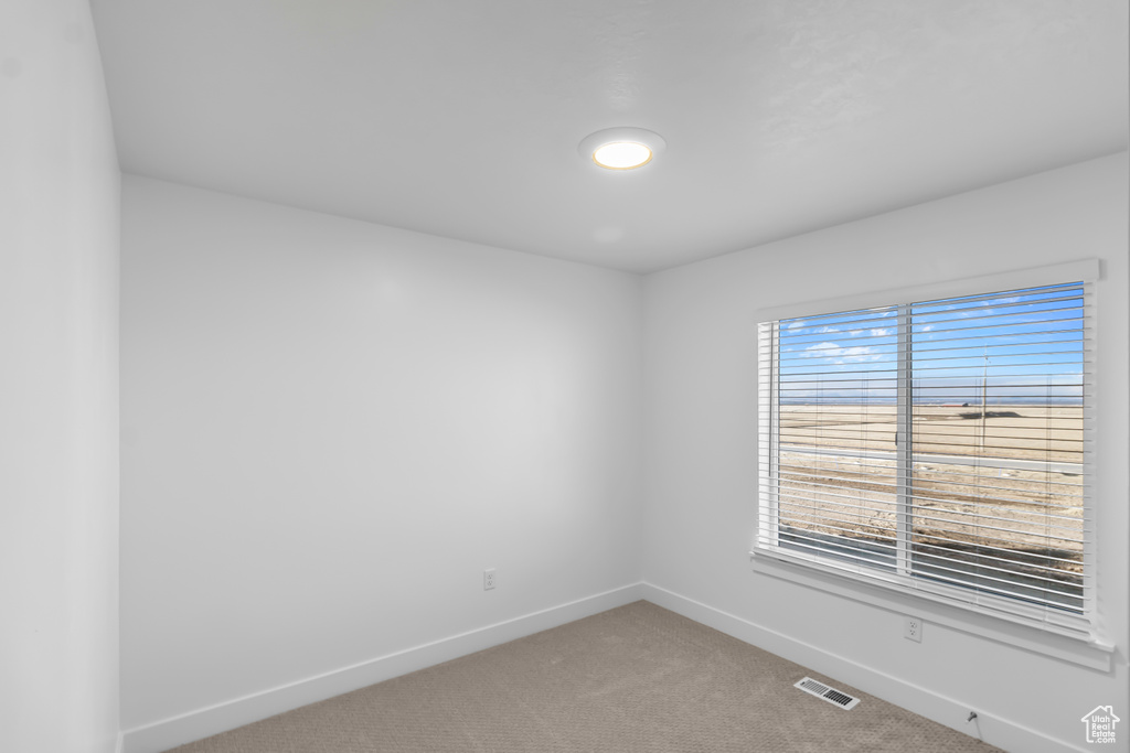 Empty room with baseboards and light carpet