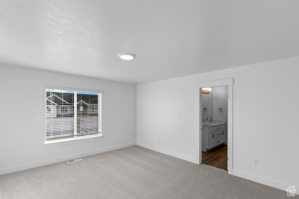 Unfurnished room with carpet floors, baseboards, and a sink