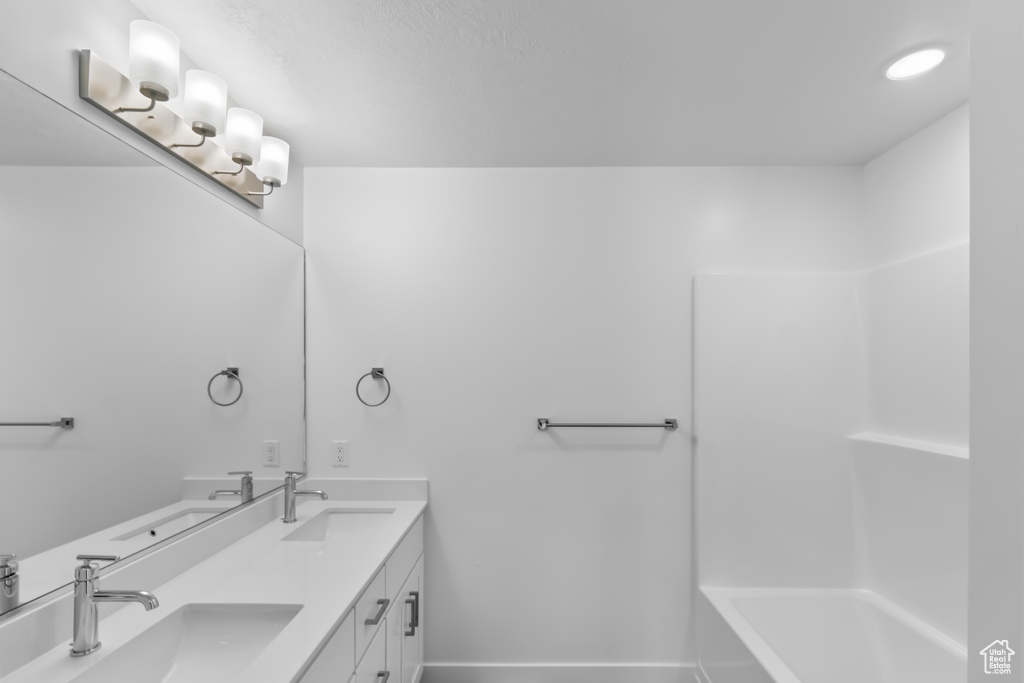 Bathroom with double vanity and baseboards