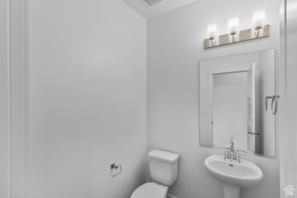 Half bathroom featuring a sink and toilet