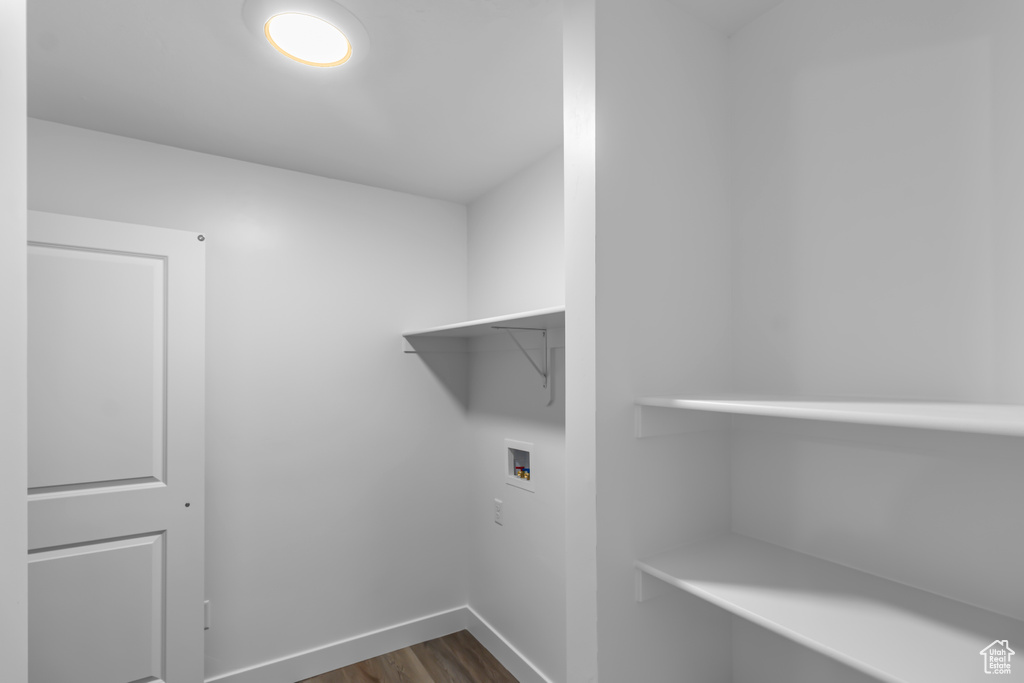 Laundry area featuring hookup for a washing machine, baseboards, and dark wood-style floors