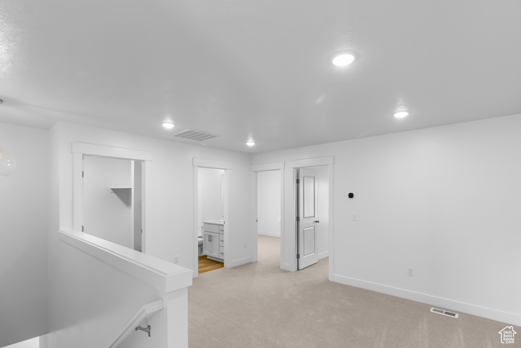 Empty room featuring recessed lighting, light colored carpet, and baseboards