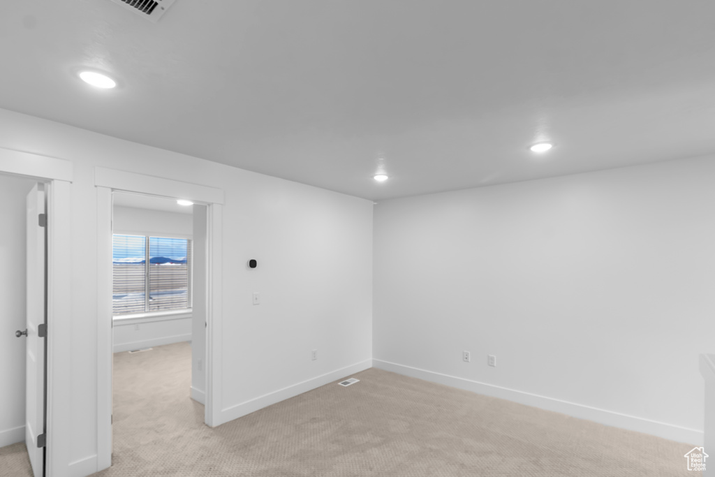 Basement with recessed lighting, light carpet, and baseboards