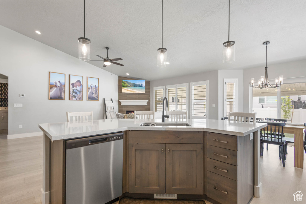 Kitchen featuring stainless steel dishwasher, a sink, light countertops, a ceiling fan, and lofted ceiling
