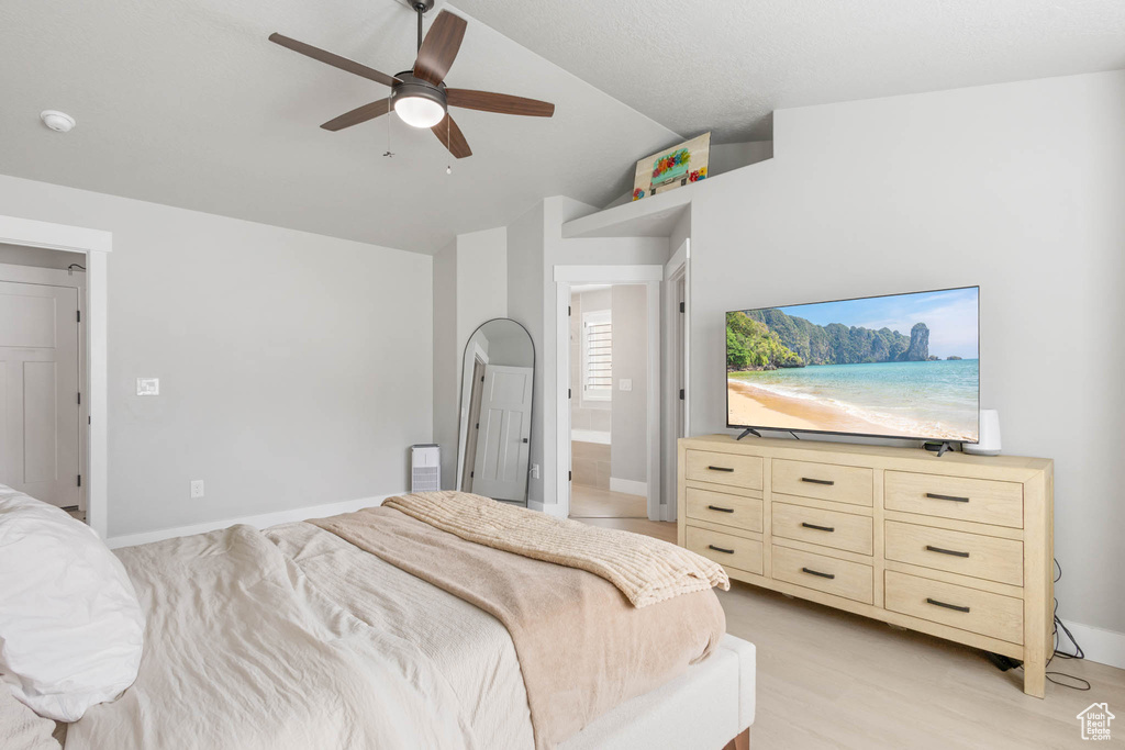 Bedroom with vaulted ceiling, a ceiling fan, baseboards, and light wood finished floors