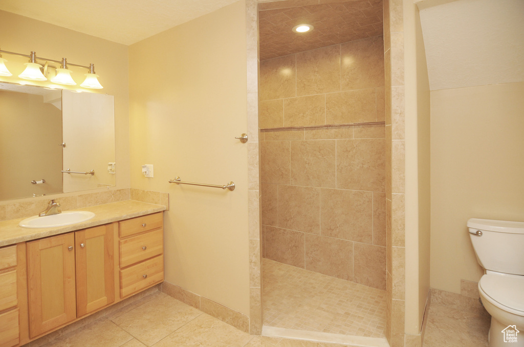 Bathroom with toilet, tile patterned flooring, a walk in shower, vanity, and recessed lighting