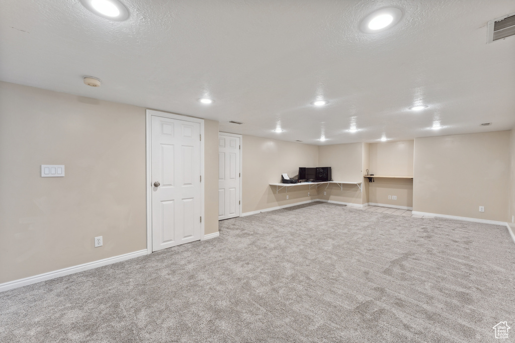 Finished basement featuring carpet floors, baseboards, recessed lighting, and a textured ceiling
