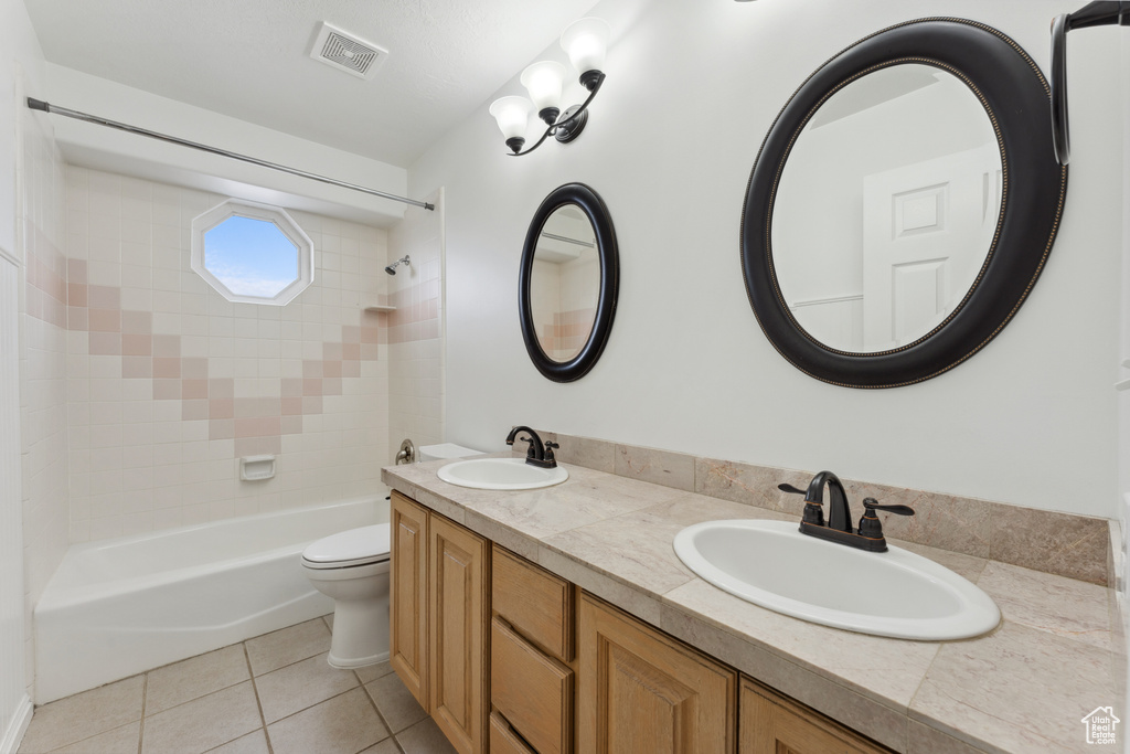 Full bathroom featuring tile patterned flooring, shower / bath combination, toilet, and double vanity