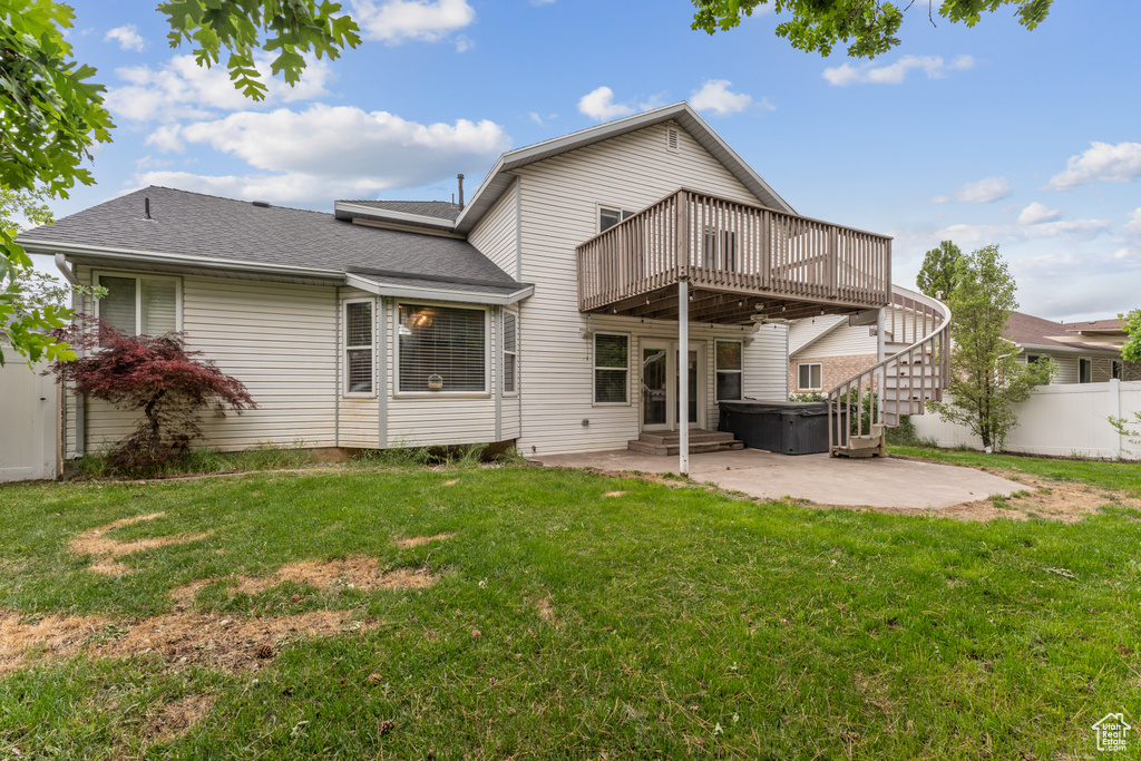 Back of property featuring a patio, a wooden deck, a shingled roof, a hot tub, and stairs