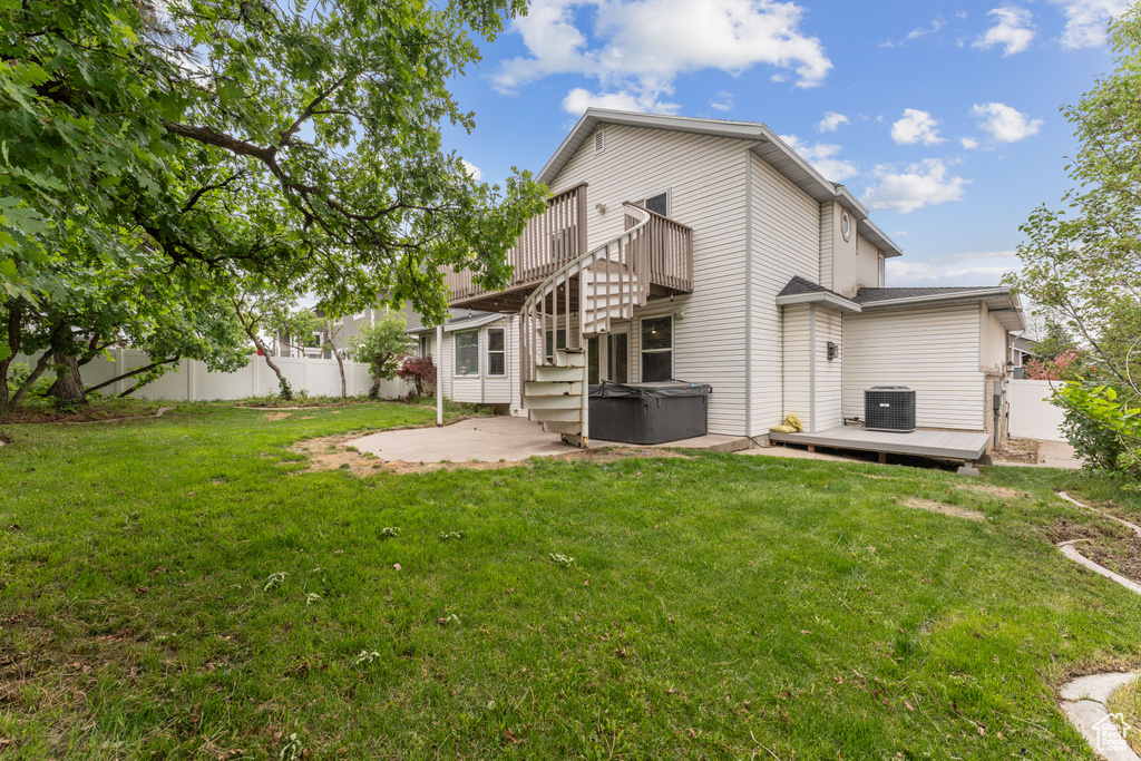 Rear view of house featuring a patio, a hot tub, cooling unit, and a wooden deck