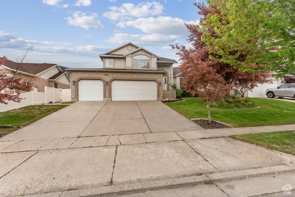 Traditional-style house featuring driveway, stucco siding, an attached garage, and brick siding