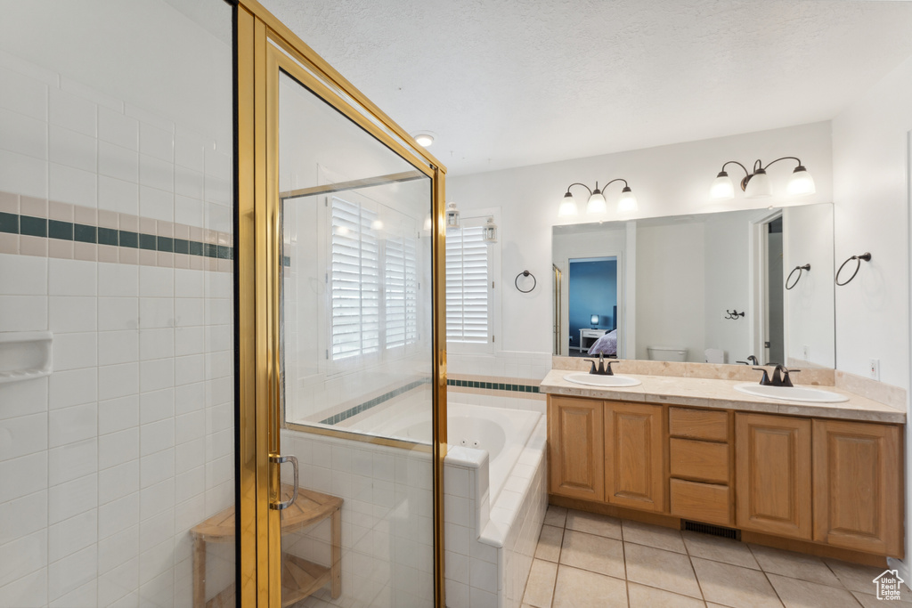 Full bath featuring a stall shower, a bath, tile patterned flooring, and double vanity