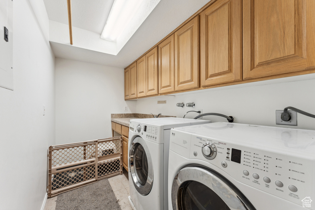 Washroom with cabinet space and washer and clothes dryer