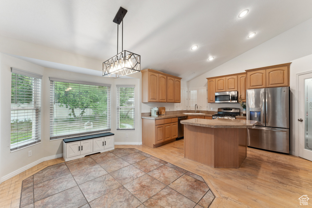 Kitchen featuring appliances with stainless steel finishes, a sink, a kitchen island, recessed lighting, and light countertops