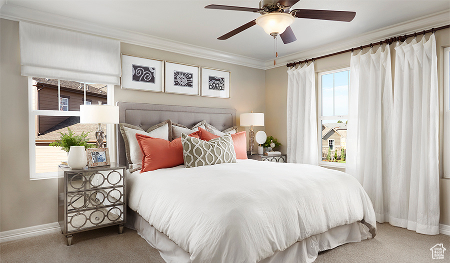 Carpeted bedroom with baseboards, ornamental molding, and a ceiling fan