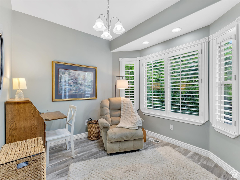 Living area featuring wood finished floors, baseboards, a chandelier, and recessed lighting