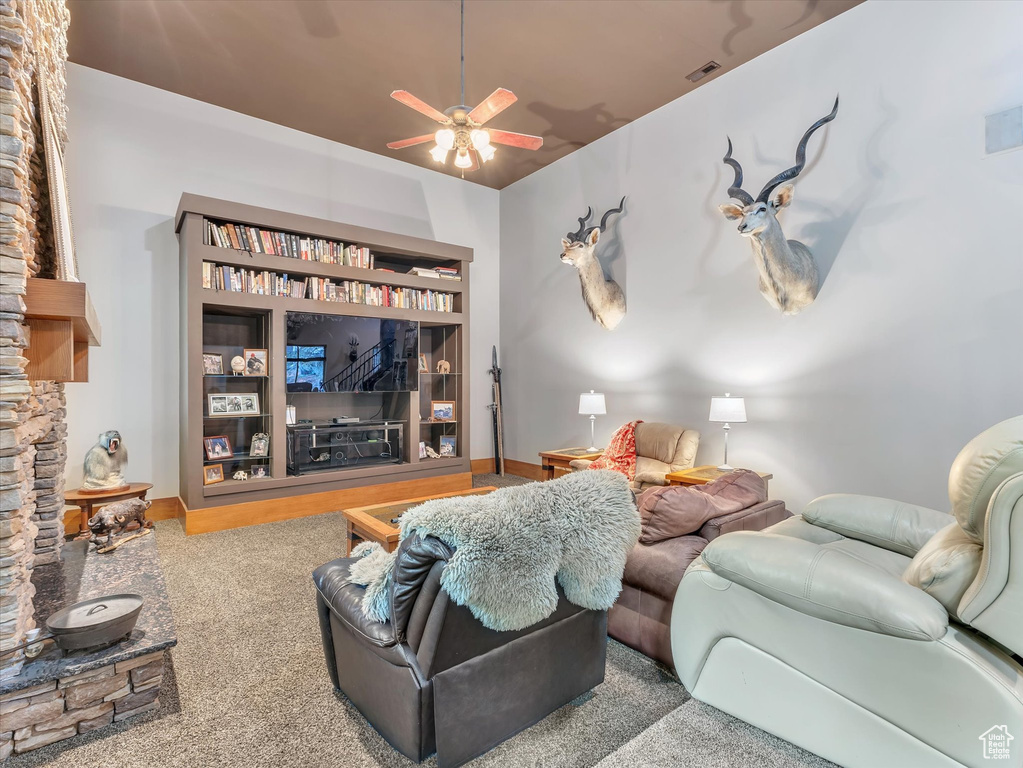 Carpeted living room with a ceiling fan