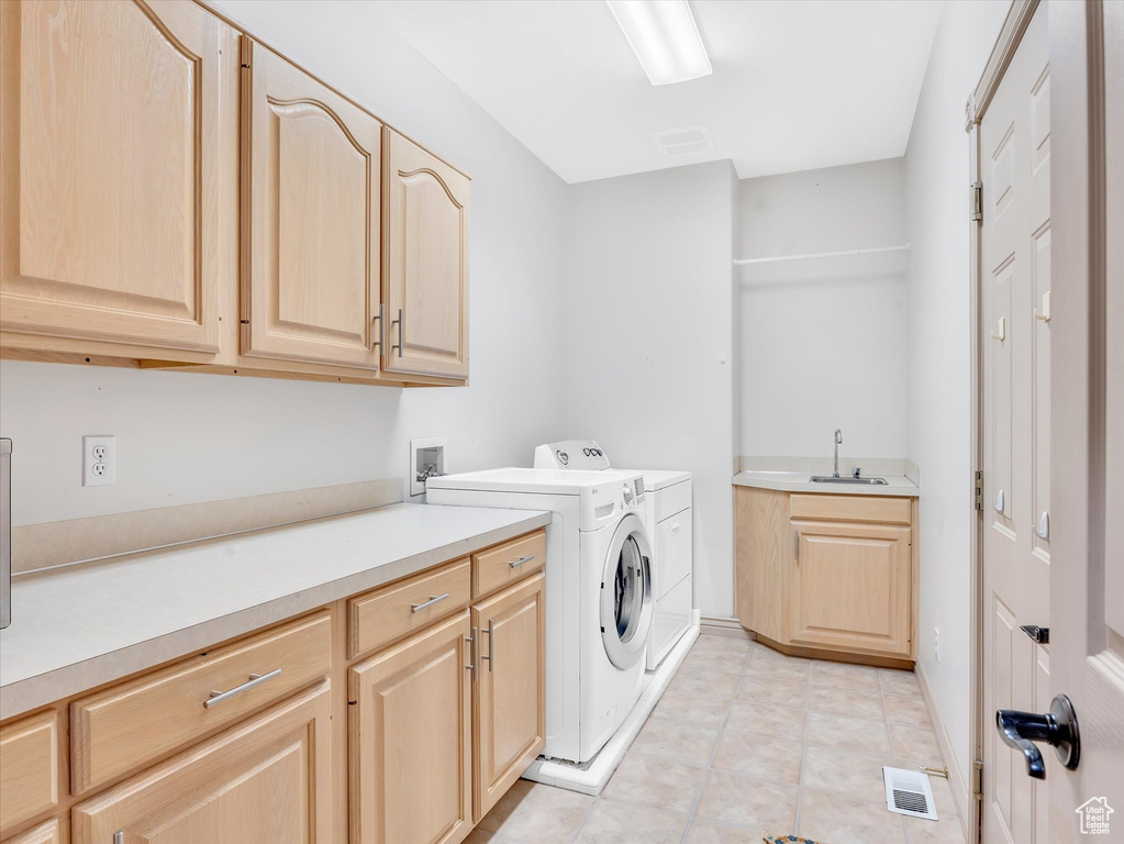 Clothes washing area featuring cabinet space and washing machine and dryer