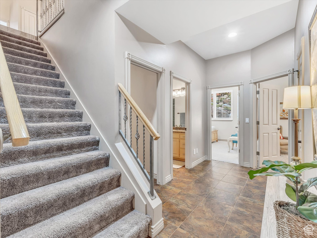 Foyer featuring stairs, baseboards, recessed lighting, and stone finish flooring