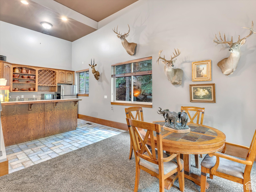 Dining space with baseboards and bar area