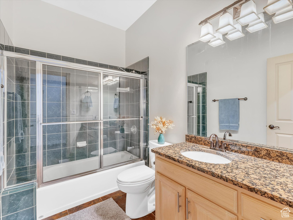 Bathroom featuring shower / bath combination with glass door, toilet, and vanity