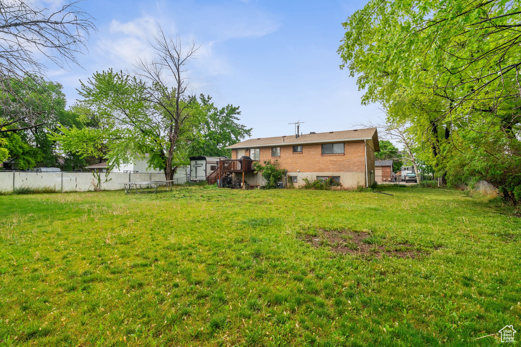 View of yard with a wooden deck and stairway