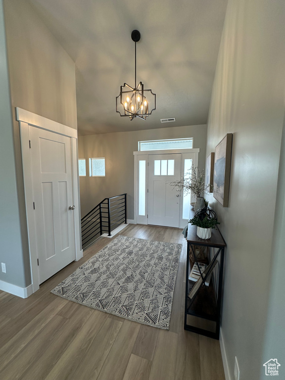 Entrance foyer with a chandelier, baseboards, and wood finished floors