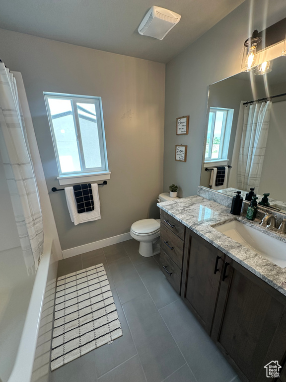 Bathroom featuring vanity, toilet, tile patterned floors, and a shower with shower curtain