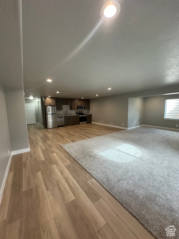 Unfurnished living room with baseboards, light wood-style floors, and recessed lighting