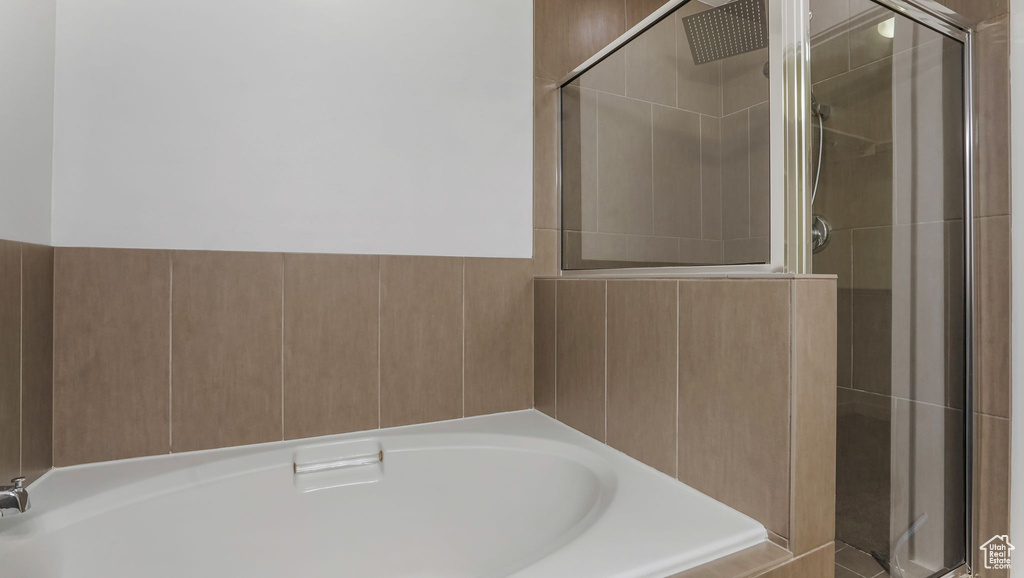 Bathroom featuring a shower stall and a bath